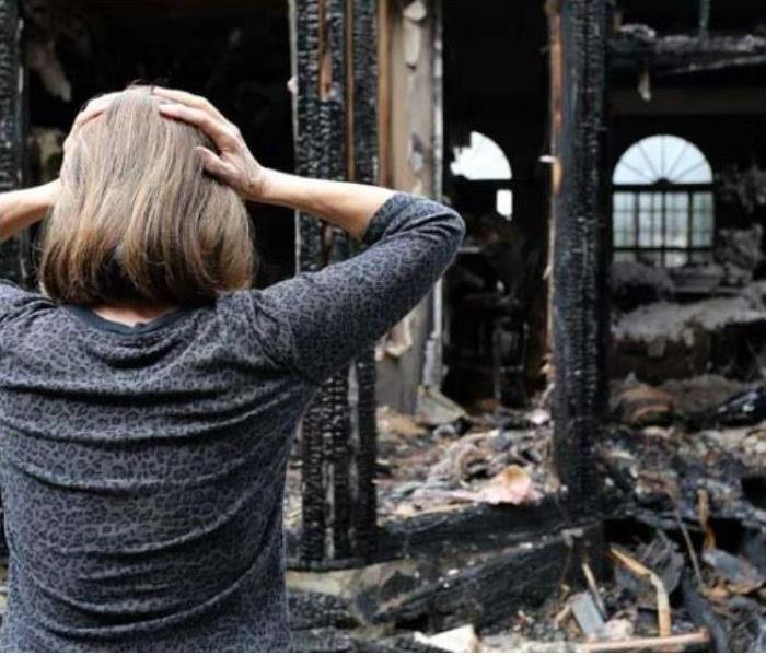 Woman Looking At Fire Devastation
